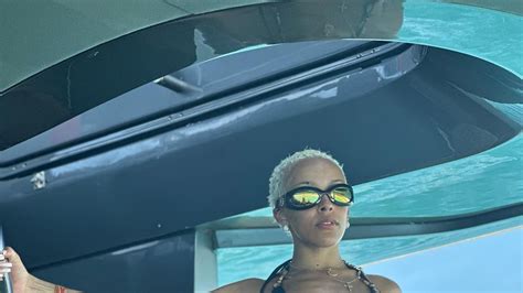 Doja Cat Vacations in a Black Bikini Embellished With Dangling。